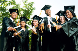 A diverse group of graduates holding their diplomas.
